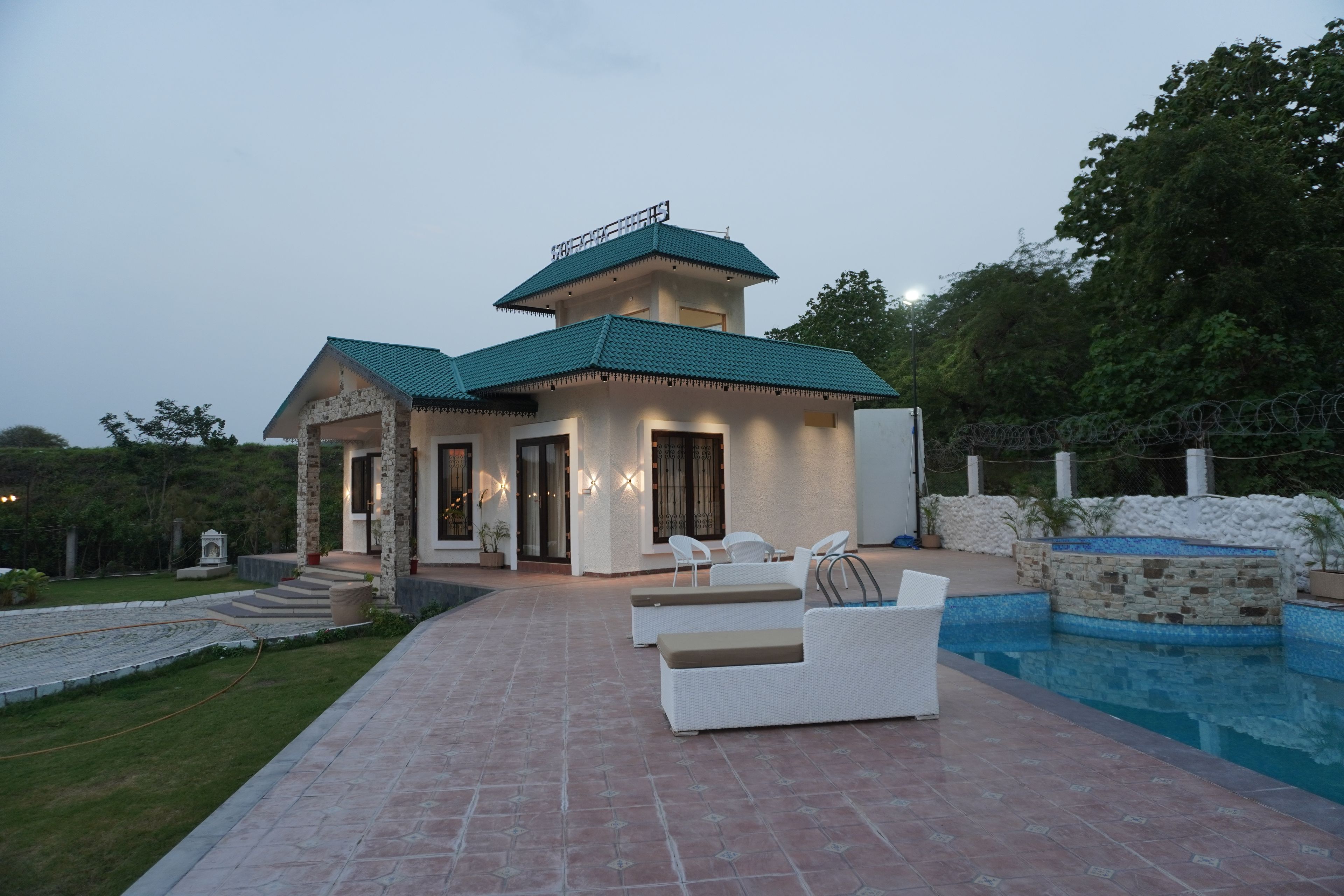 A two-story building with a swimming pool and outdoor seating.