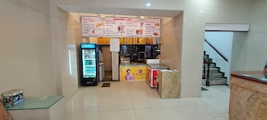 A cafe with a menu board, a Pepsi refrigerator, and a counter.