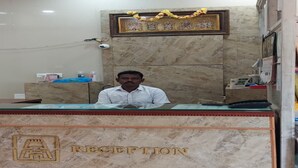 A reception desk with a marble top and a framed picture above it. - Ajantha Guest House (Puducherry)