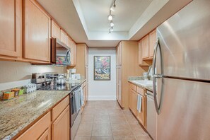 A kitchen with wooden cabinets, stainless steel appliances, and a tiled floor. - 3 Mi to Camelback Mtn! Snowbird Escape w/ Pool (Phoenix)
