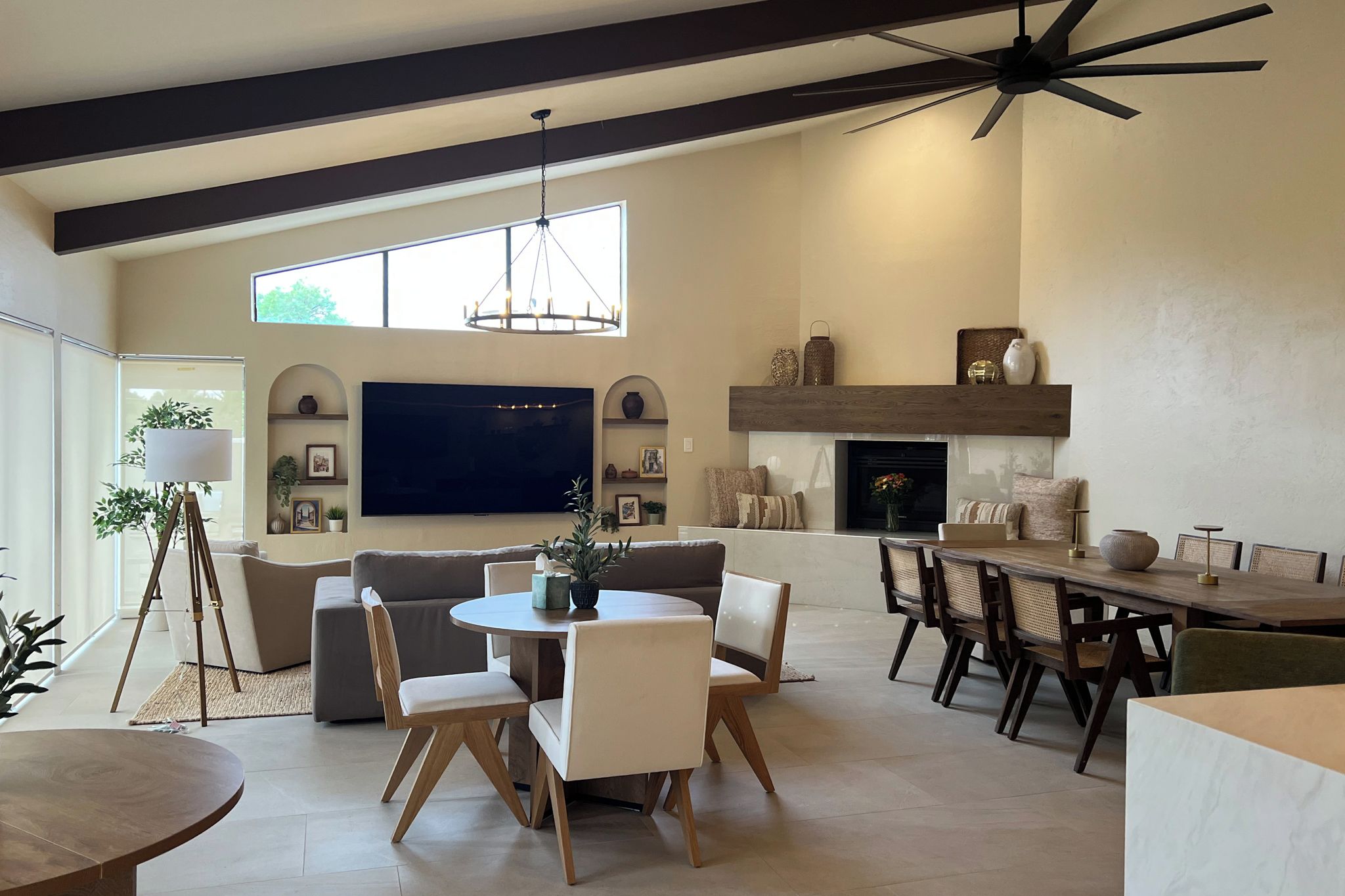 A spacious living room with a large flat-screen TV, a fireplace, and a dining area with a wooden table and chairs.
