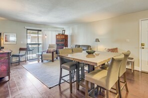 A spacious living room with a large wooden dining table, comfortable seating, and a view to a balcony. - 3 Mi to Camelback Mtn! Snowbird Escape w/ Pool (Phoenix)