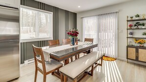 A modern kitchen with a built-in refrigerator, a dining table with benches, and a window with blinds. - All-Season Fun! Tobyhanna Getaway w/ Lake Access (Tobyhanna)