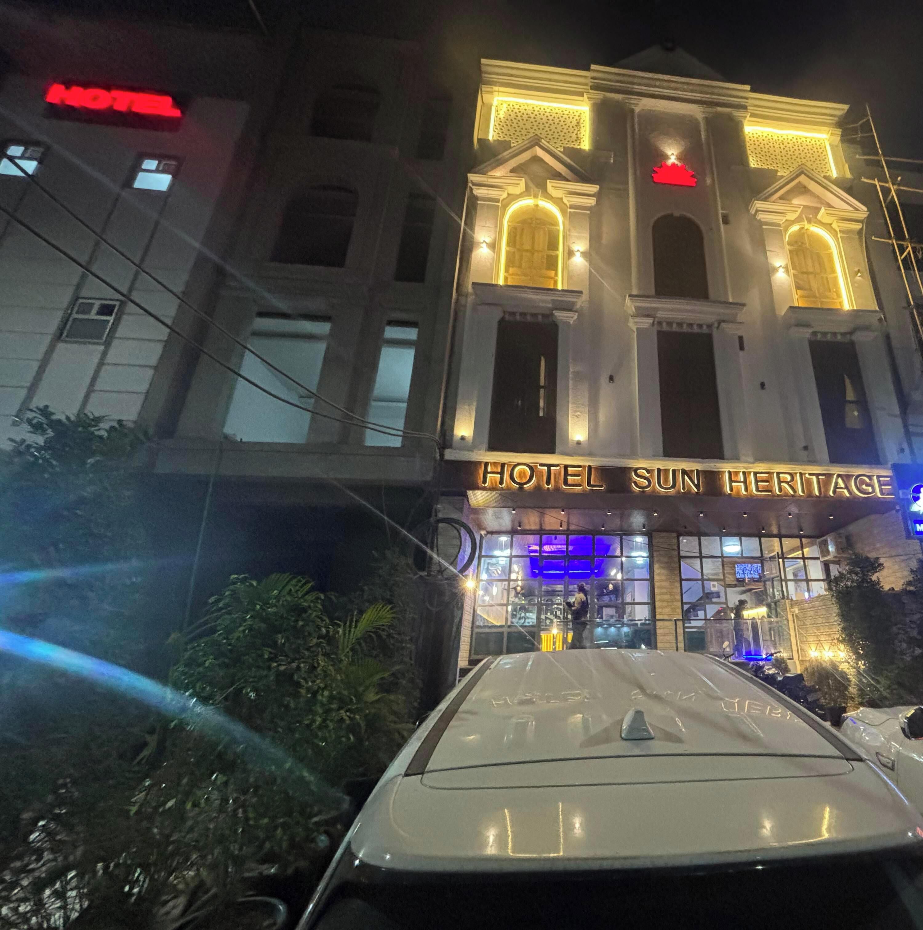 Un hotel con fachada clásica, letreros iluminados y una entrada visible.