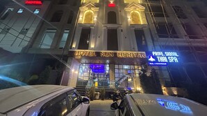 Un hôtel dont l’enseigne, bien visible, porte l’inscription « HOTEL SUN HERITAGE ».