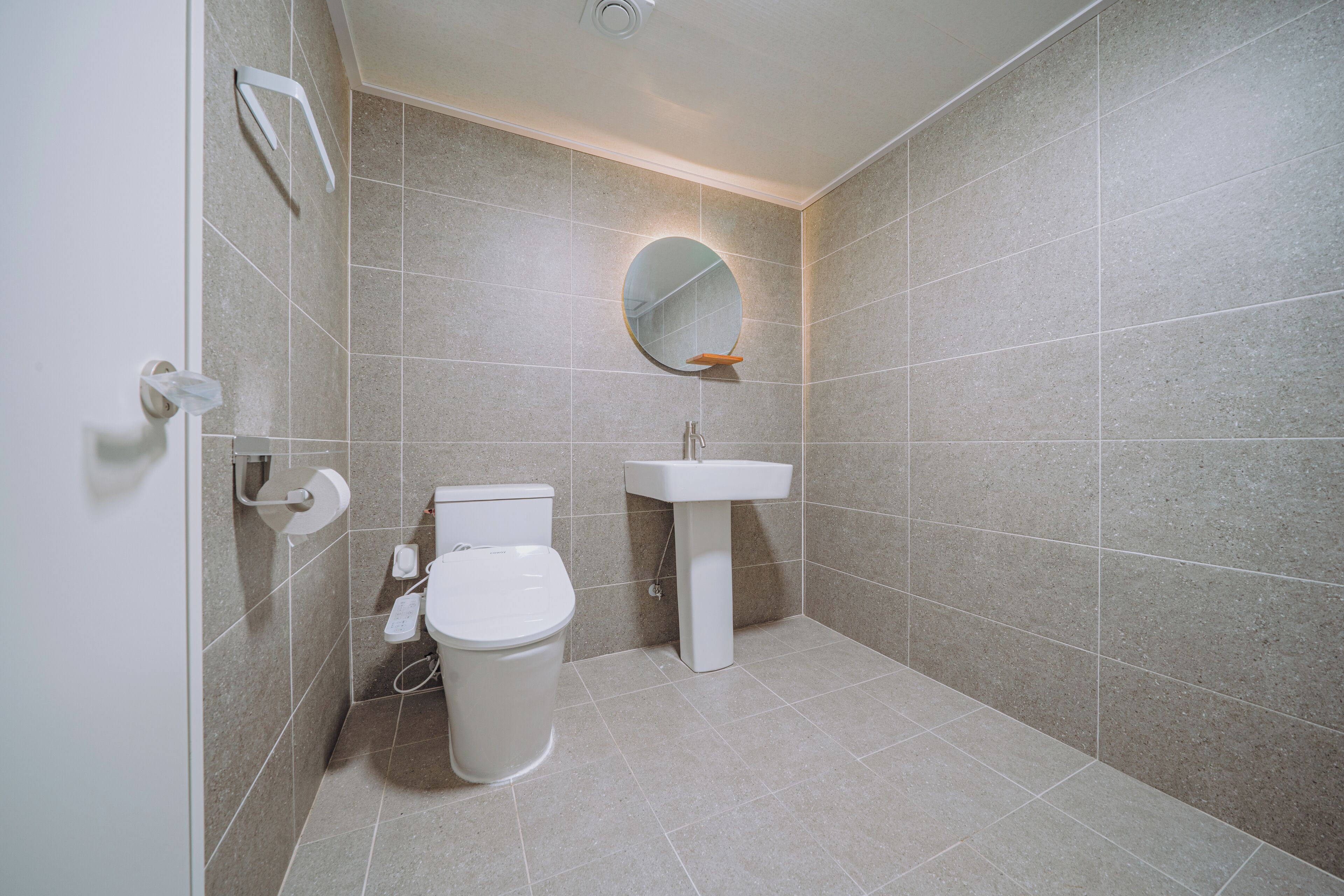 Un baño con inodoro, lavabo y espejo.