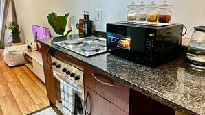A kitchen with a stove, microwave, and various kitchen items. - Stay Central. Stay Comfortable. Work & Play in JHB central (Johannesburg)