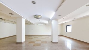 A spacious, empty room with a checkered floor, white walls, and a chandelier. - Fabhotel Fortune Residency - Nr Sarai Rohilla Railway Station (New Delhi)