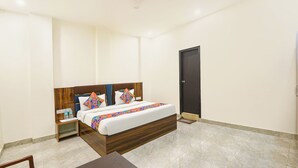 A bedroom with a bed, nightstands, a desk, a chair, a door, and a ceiling fan. - Fabhotel Fortune Residency - Nr Sarai Rohilla Railway Station (New Delhi)
