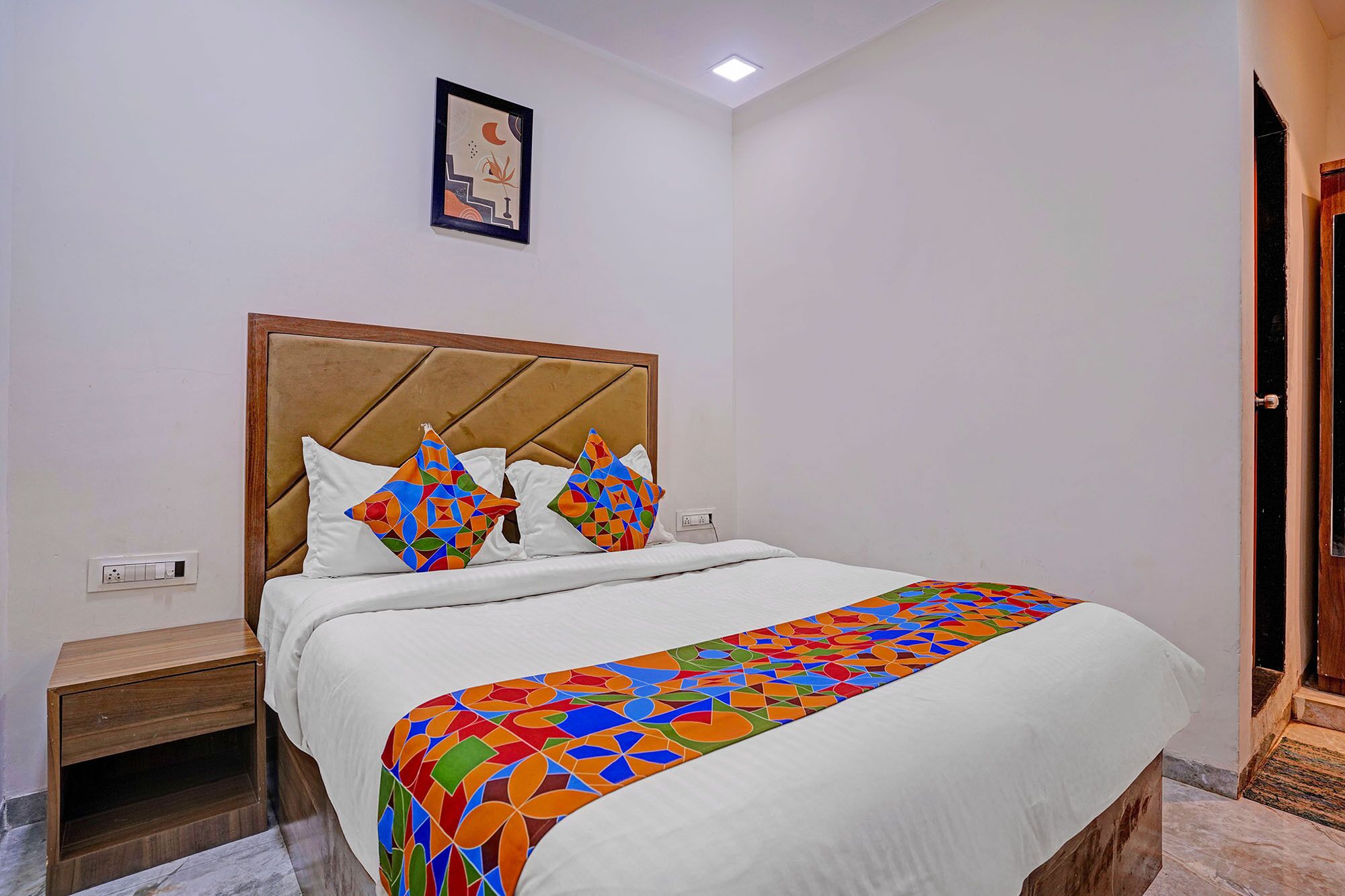A neatly made bed with a patterned bedspread, a headboard, and two pillows.