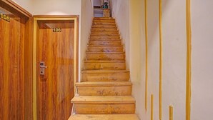 A wooden staircase leading to a room with a door marked 106. - Fabhotel Beverly Plaza (Mumbai)