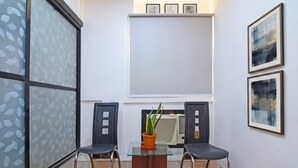 A small room with two chairs, a table, and a potted plant. - Fabhotel Demattrie Budget (Kolkata)