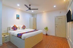 A modern hotel room with a bed, a wardrobe, a ceiling fan, and a television. - Fabhotel Demattrie Budget (Kolkata)
