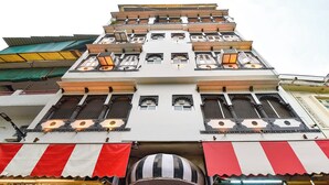A multi-story building with a shop on the ground floor, balconies, and decorative window grills. - Fabhotel Boutique Stays Lake Pichola (Udaipur)