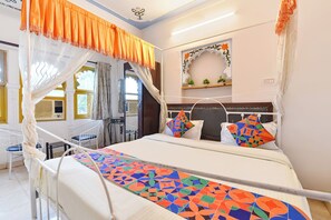 A bed with a colorful geometric bedspread, a canopy, and decorative pillows. - Fabhotel Boutique Stays Lake Pichola (Udaipur)