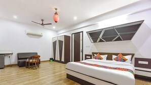 Een moderne hotelkamer met een groot bed, een bureau, een stoel en een kledingkast.