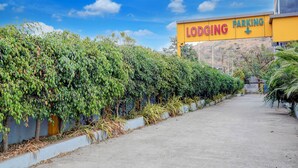 A pathway leading to a building with a 'LODGING PARKING' sign. - Fabhotel Raj (Bhor)