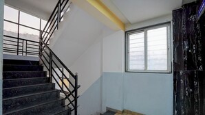 A staircase with black railings leading to a landing. - Fabhotel Raj (Bhor)