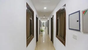 Un pasillo largo y estrecho con puertas a ambos lados, que conduce a habitaciones individuales.