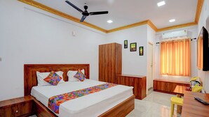 A bedroom with a wooden bed, a wardrobe, a desk, a chair, and a ceiling fan. - Via Guru Residency - Kengeri (Bangalore)