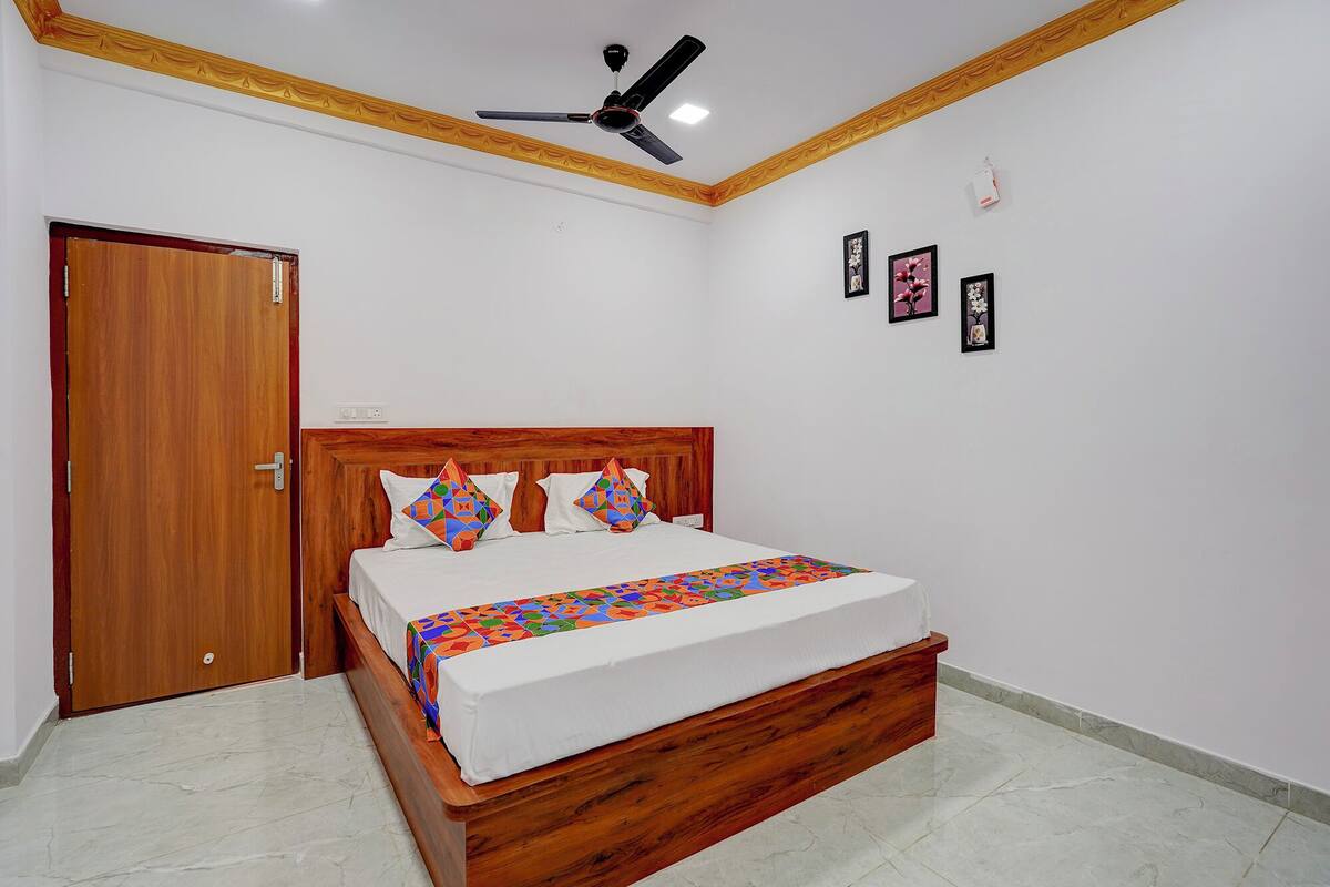 A bedroom with a wooden bed, white bedding, and a ceiling fan.