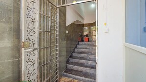A staircase with a patterned door and a tiled floor. - Via Guru Residency - Kengeri (Bangalore)