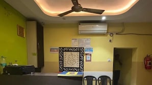 Uma área de recepção com ventoinha no teto, ar condicionado e balcão de atendimento.