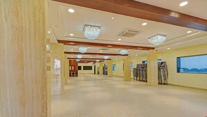 Eine geräumige Hotelhalle mit Marmorböden, Holzbalken und Kronleuchtern.