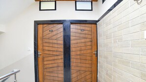 A double wooden door with numbers 201 and 202, a metal handrail, and a tiled wall. - Fabhotel Div Palace (Indore)