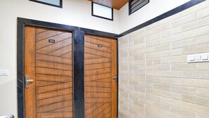 Two wooden doors with numbers 201 and 202, a tiled wall, and a light switch. - Fabhotel Div Palace (Indore)