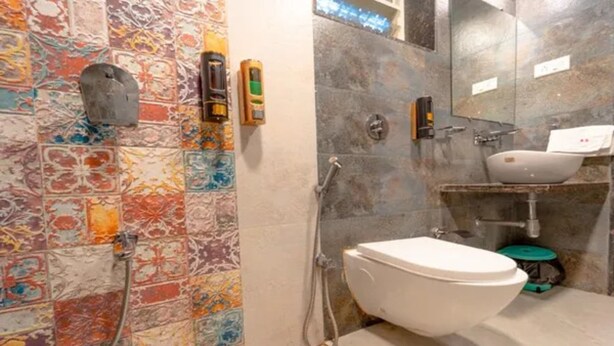 Une salle de bain avec des toilettes blanches, une douche et un lavabo.