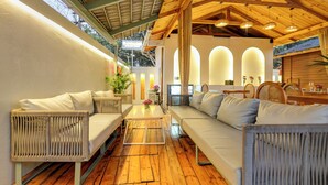 A cozy, well-lit outdoor seating area with wicker furniture, a wooden floor, and a view of the sky. - FabHotel The Village Boutique Resort - Nr Chapora Fort, Vagator (Vagator)