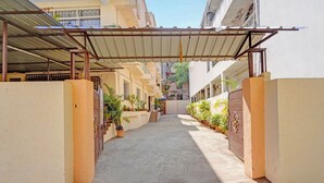 Un carrer estret amb una passera coberta, plantes en testos i una entrada reixa.