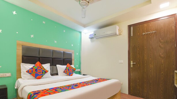 Een hotelkamer met een bed, een houten deur en een airconditioning.