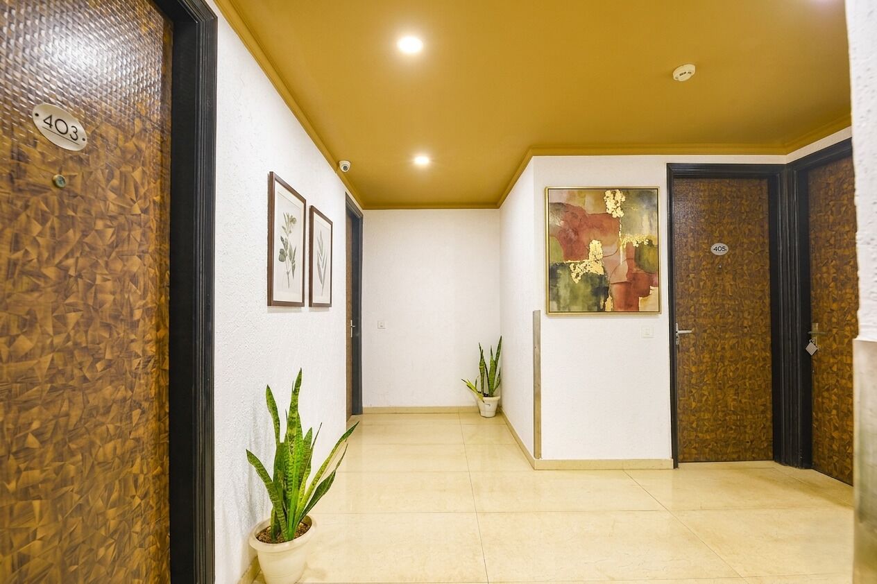 A hallway with a number '403' on the wall, a potted plant, and a door with a number '405' on it.