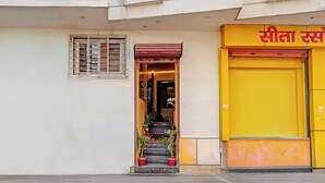 L'ingresso di un edificio con una porta gialla e una finestra con grate metalliche.