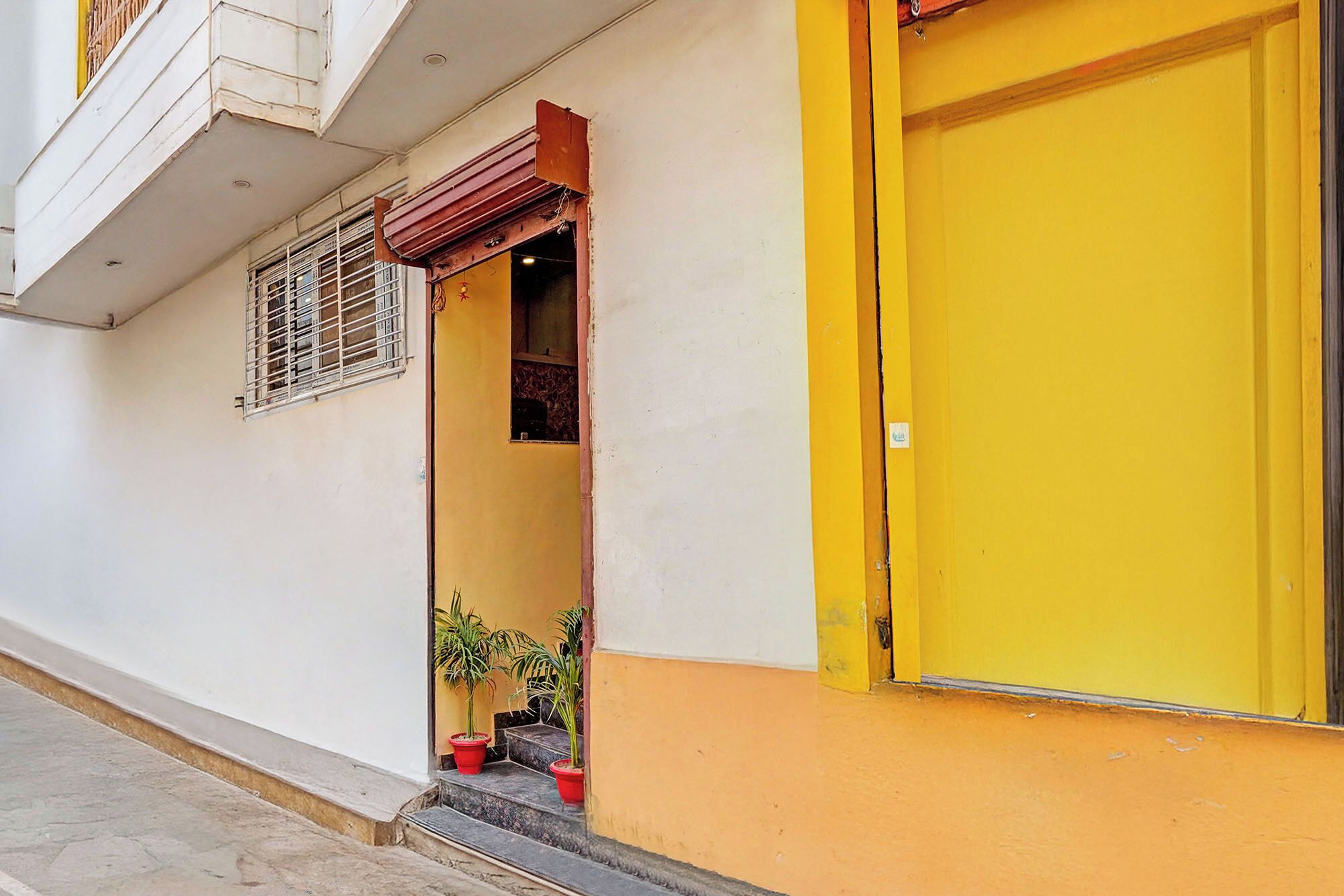Un edificio con una puerta amarilla y una pequeña entrada con escalones.