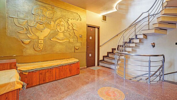 Una hall d'hotel moderna con una scala a chiocciola, un grande murale e una reception.