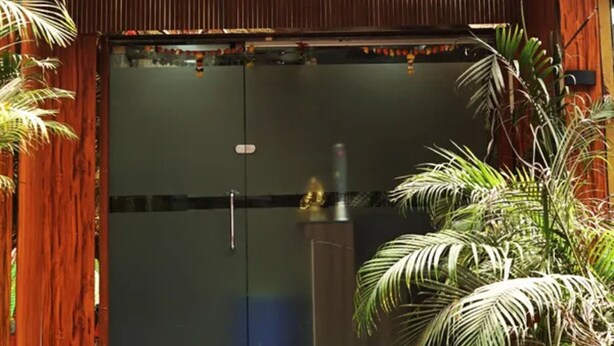 The exterior of Hotel Star Hill with a wooden facade, a glass entrance, and steps leading up to the door. - Fabhotel Star Hill (Mumbai)