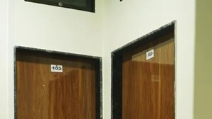 A set of wooden doors with black trim and a metal handrail in front. - Fabhotel Star Hill (Mumbai)
