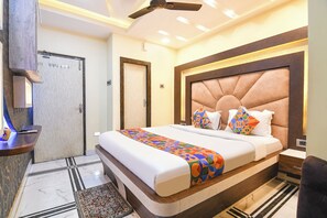 Ein Hotelzimmer mit einem großen Bett, einem Deckenventilator und einer Badezimmertür.