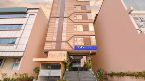 Un hotel con una fachada moderna, una escalera que conduce a la entrada y un cartel que dice 'fabHOTELS'.