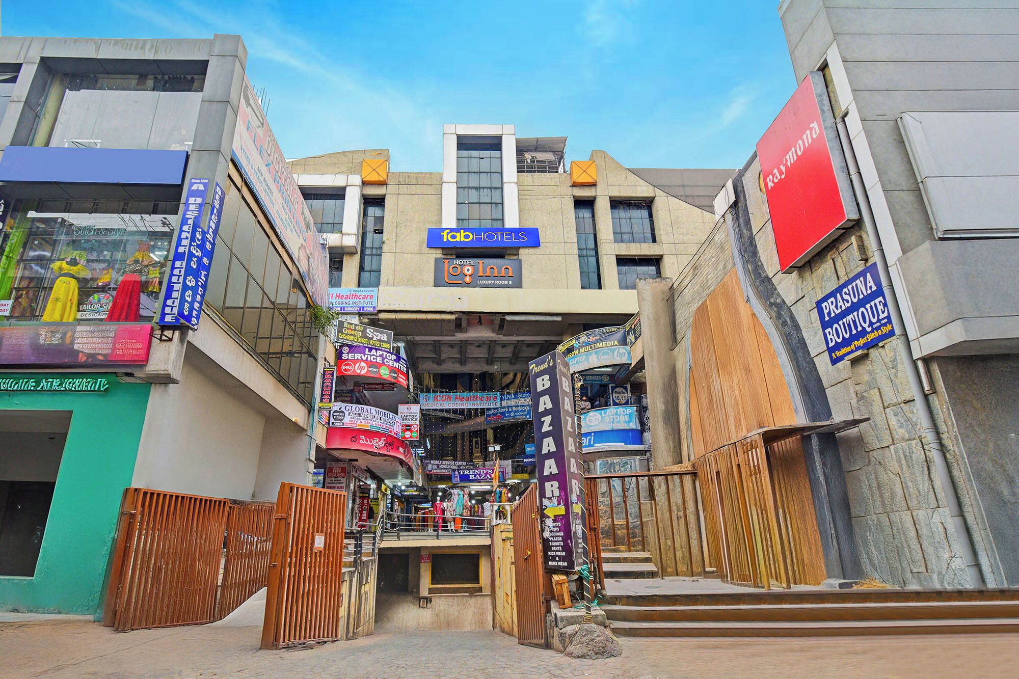 A hotel entrance with multiple signs for various businesses, including a laptop service center and a medical center.