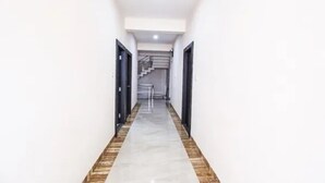 Un estrecho pasillo con suelo de baldosas que conduce a una escalera.