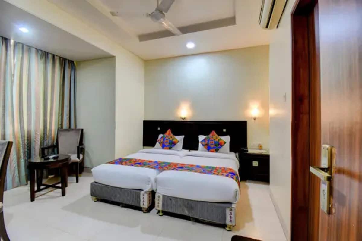 Habitación de hotel con cama doble, escritorio, silla y televisor.