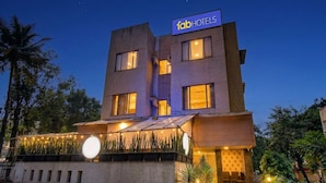 Un edificio moderno con un letrero que dice 'fabHOTELS' en la parte superior.