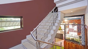 Un escalier avec des rampes en métal menant à une pièce dotée d’une fenêtre et d’une porte avec un portail en métal.