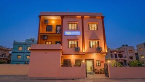 Un immeuble à plusieurs étages, sur lequel on peut voir une enseigne indiquant « fab hotels », ce qui signifie qu’il s’agit d’un établissement hôtelier.