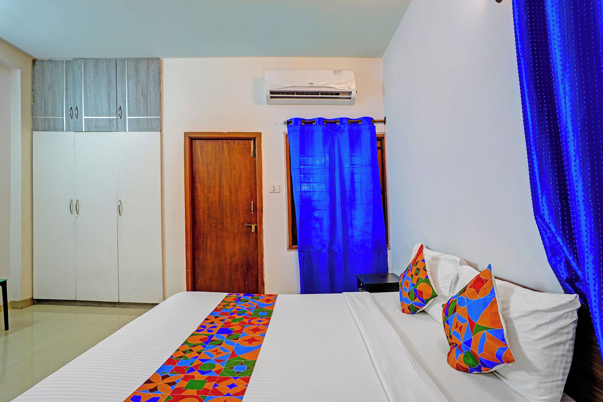 Un dormitorio con cama, armario, puerta y equipo de aire acondicionado.
