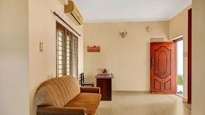 Una habitación con un sofá, una puerta y una pequeña mesa.